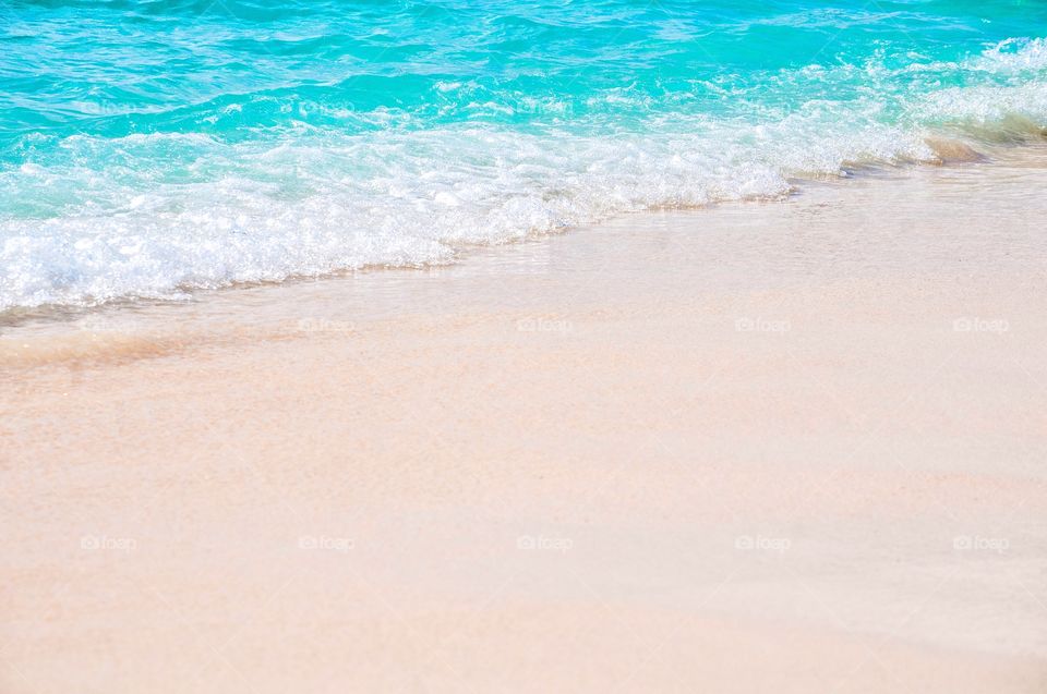 Clear beautiful waves roll over the white sand beach of Grand Turk. 