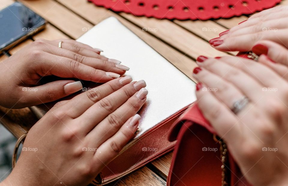 Close-up photo of two pairs of hands with painted nails