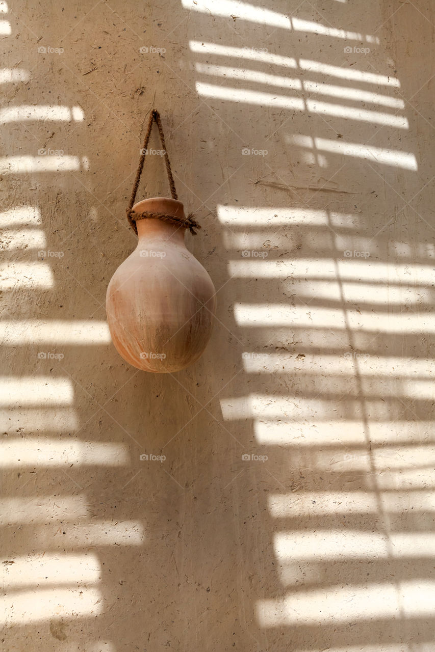 Traditional clay pot with interesting shadows on the wall