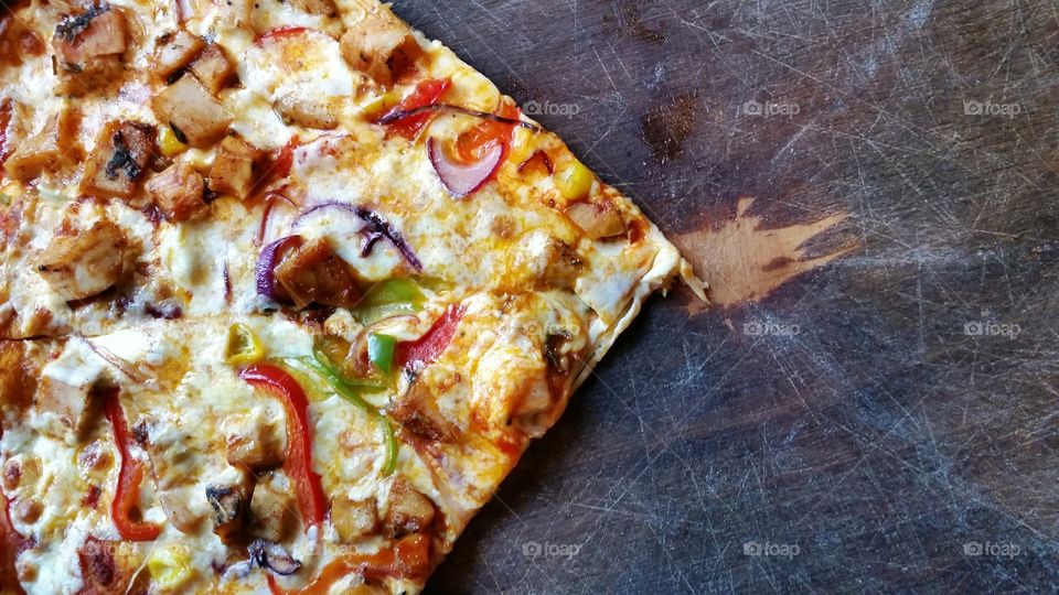 A slice of pizza on a wooden board