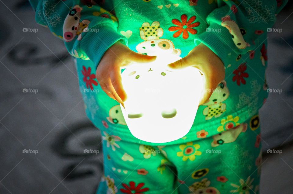 Little girl holding a nightlight in her hands