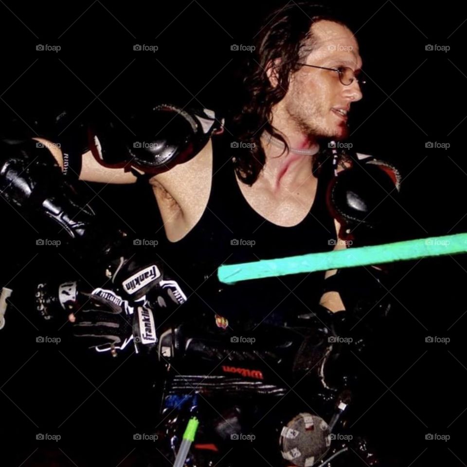 A saber provides a bright pop of color on a black background.