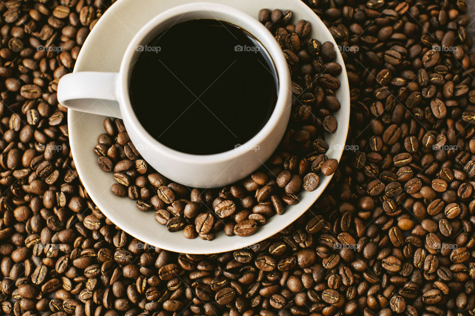 Flat lay top view of black coffee with coffee beans 