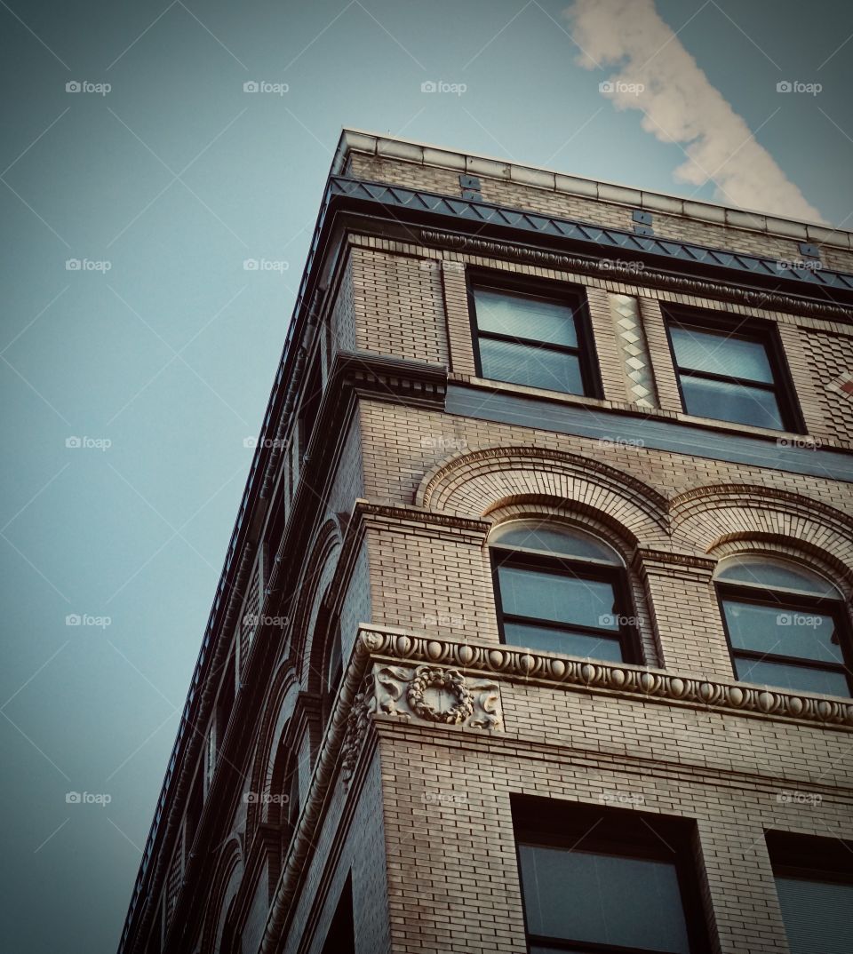 Old 1920's building with tan brick and blue ornate design.