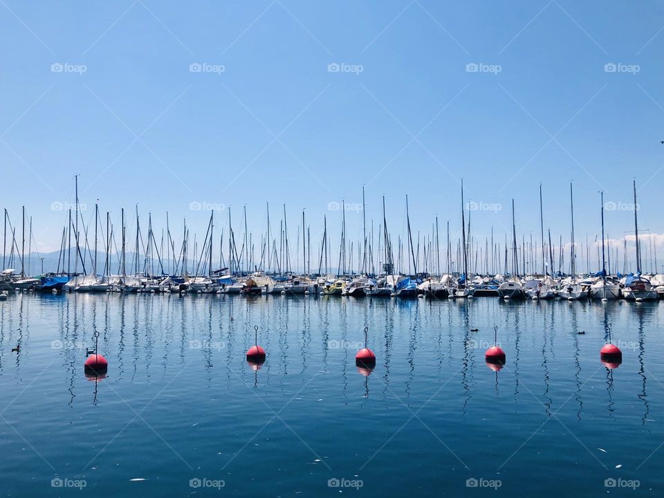 Moored boats and boat sails at Ouchy port in Lausanne, Switzerland, blue color palette 