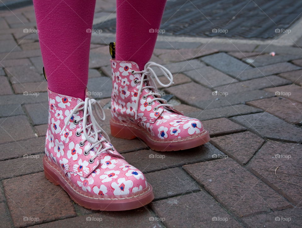 Pink floral boots in pink tights on a pink pavement