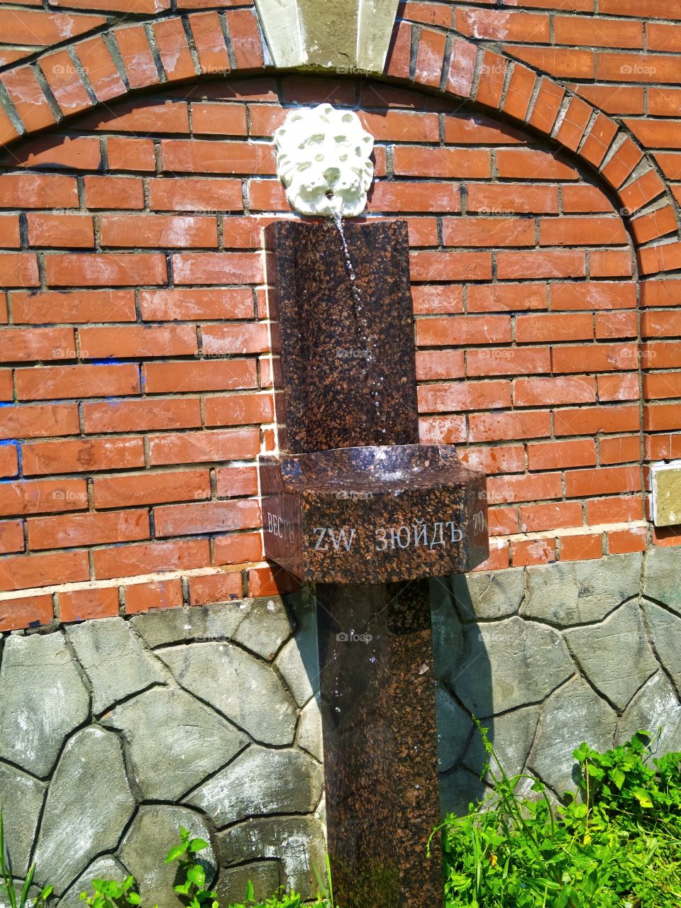 Marble antique drinking column on which the cardinal points are carved in Latin