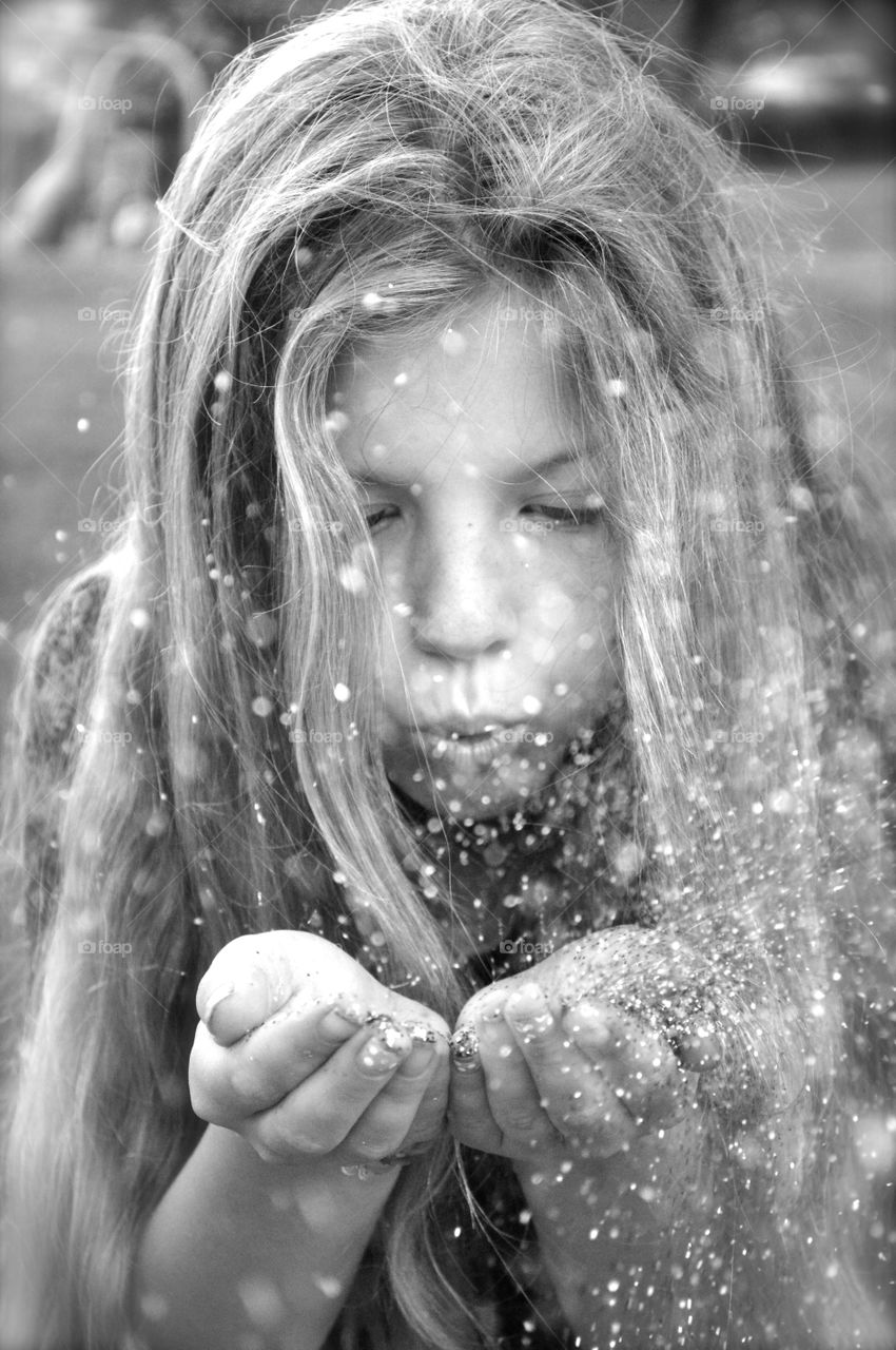 Portrait of a young girl blowing water