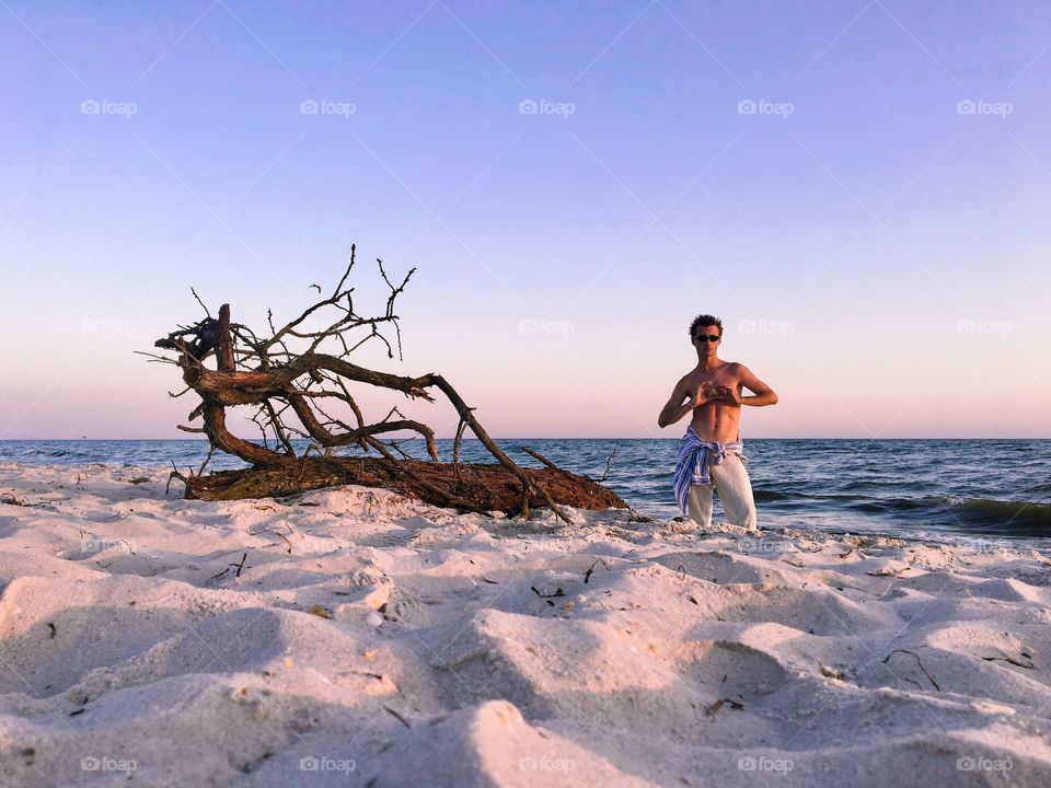Fantastic tree having rest on the seaside. With handsome guy as his companion. 