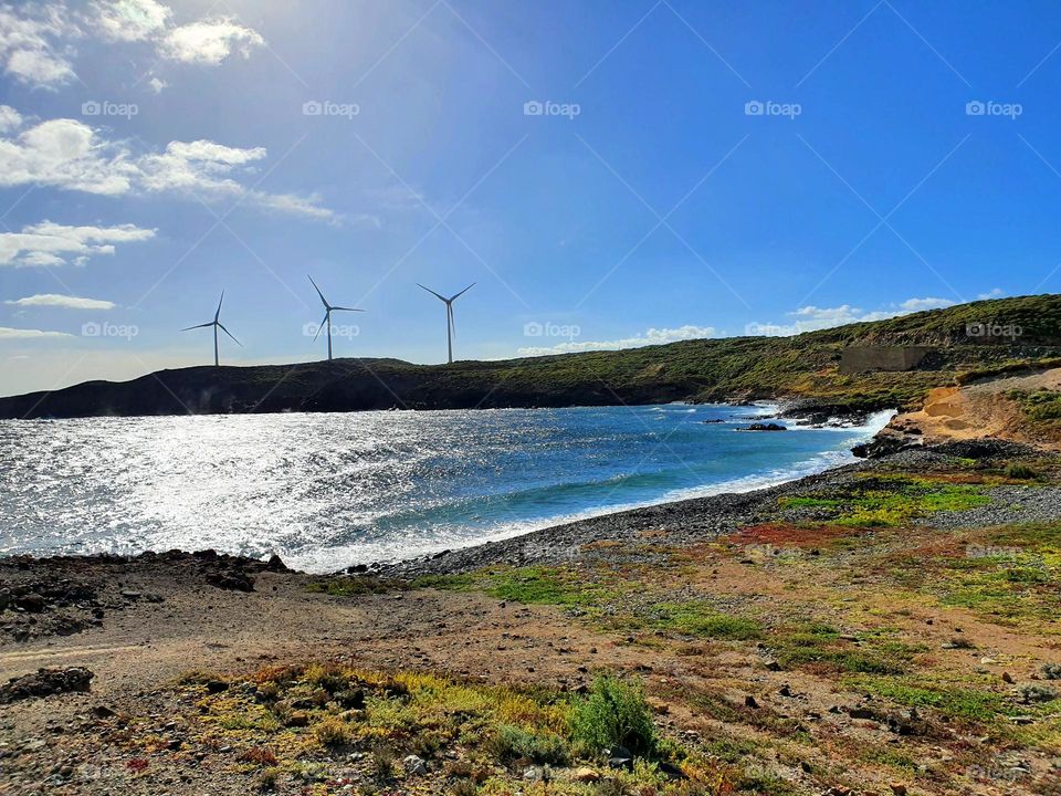 Landscapes - three wind turbines standing alone on the coast