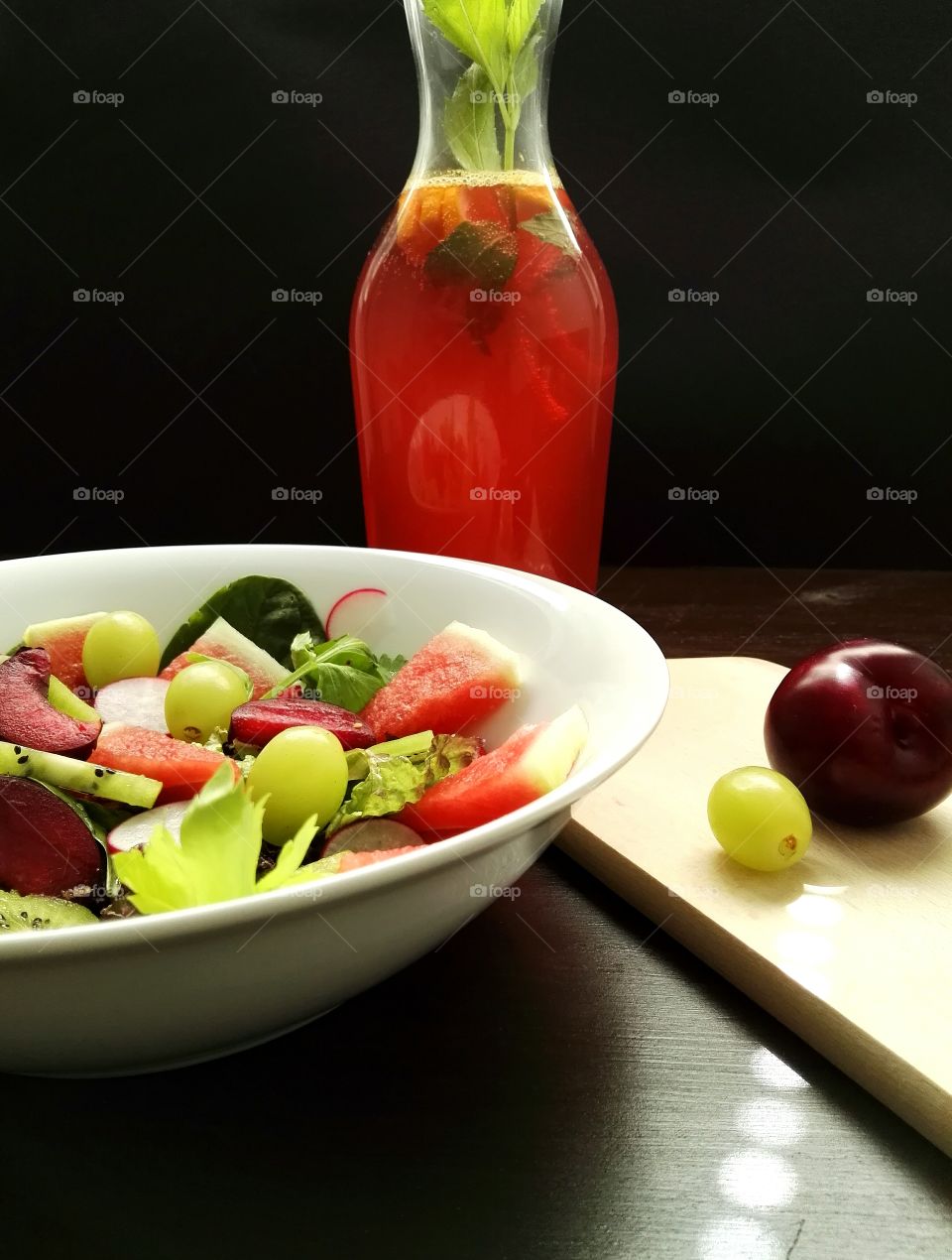 Salad with fruits and cutting board