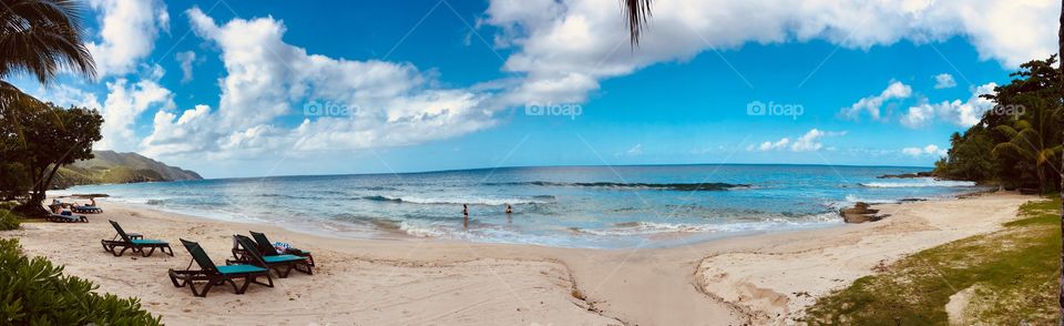 Tropical panoramic view of the ocean landscape from a warm secluded sandy beach 