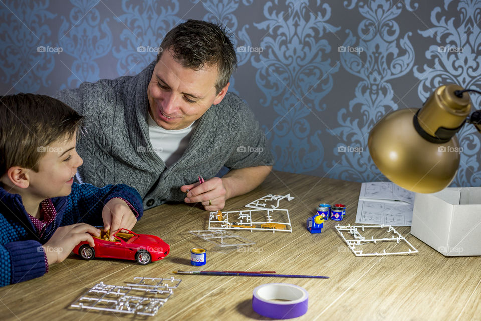 father and son building a model car togheter