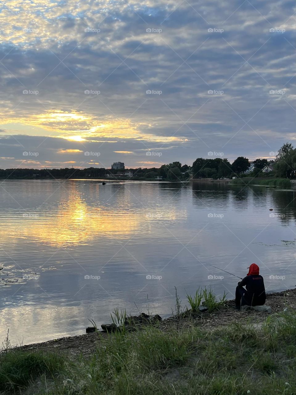 Summer. Sunset. Nice summer evening. River and fisherman.