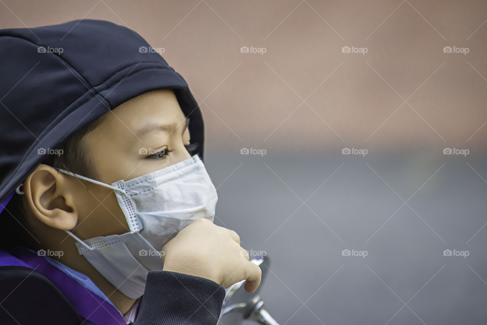 Asean Boys wear a mask to prevent dust in Bangkok ,Thailand.