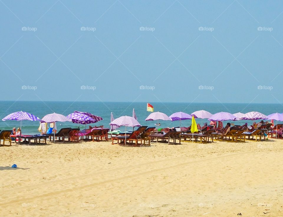 blue sea, purple umbrellas and white sand