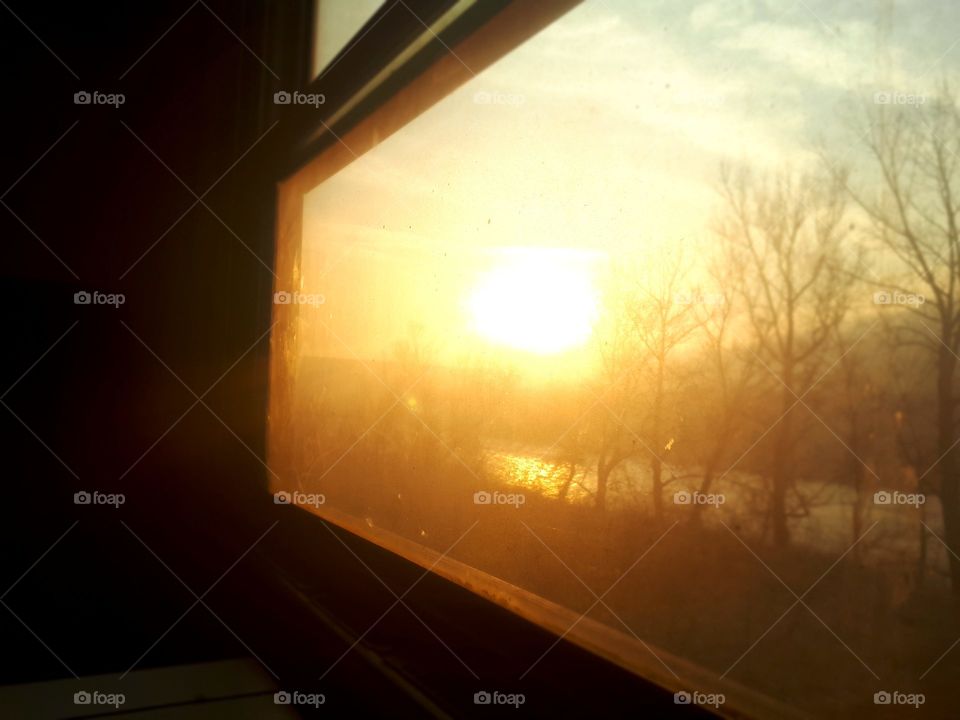a view of the sunset through the window of the old passenger wagon