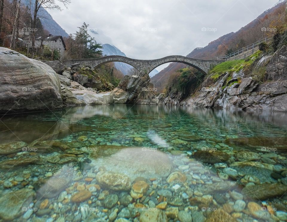 Stone bridge in switzerland ober a clear blue river