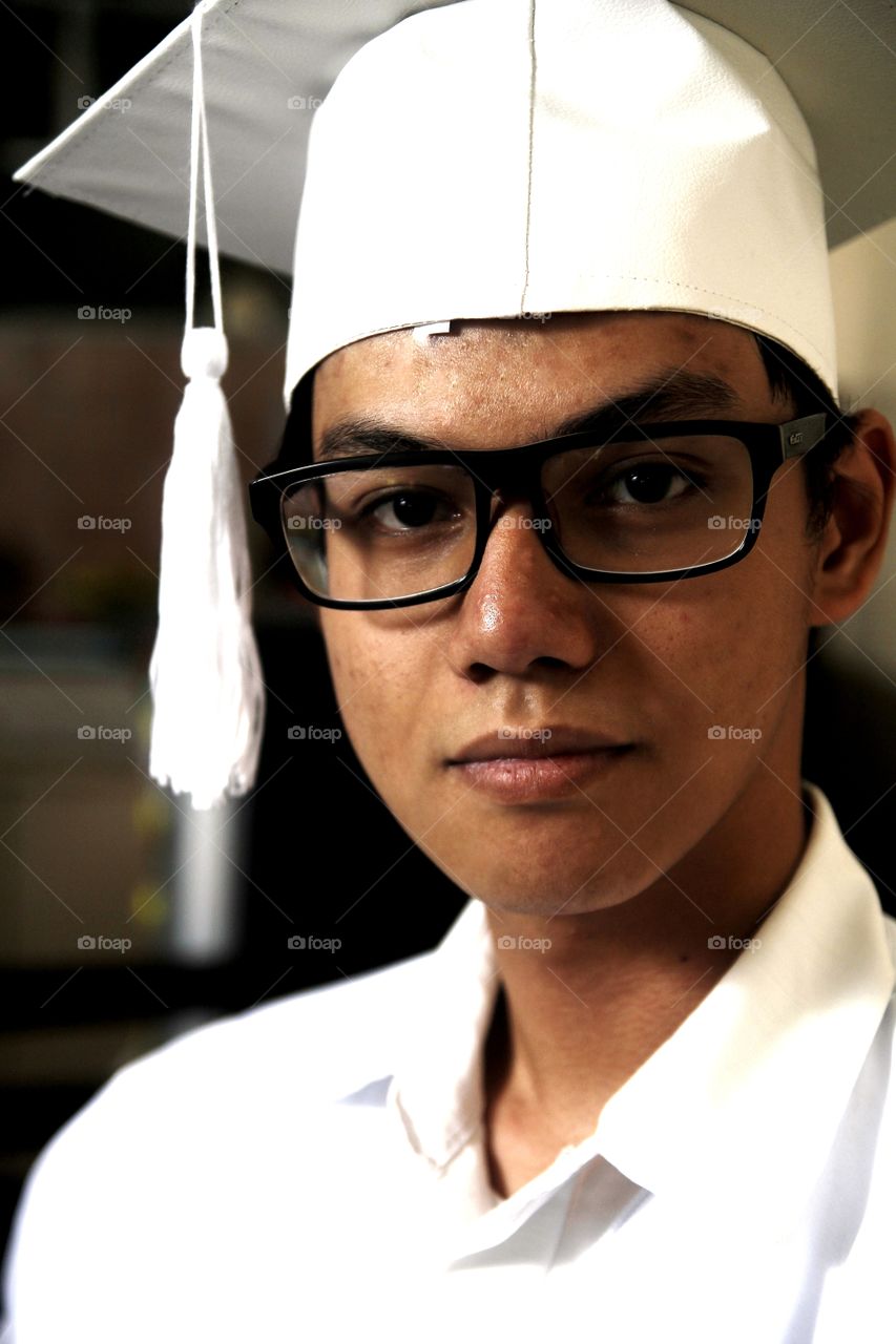 portrait of an Asian teen wearing school graduation clothes