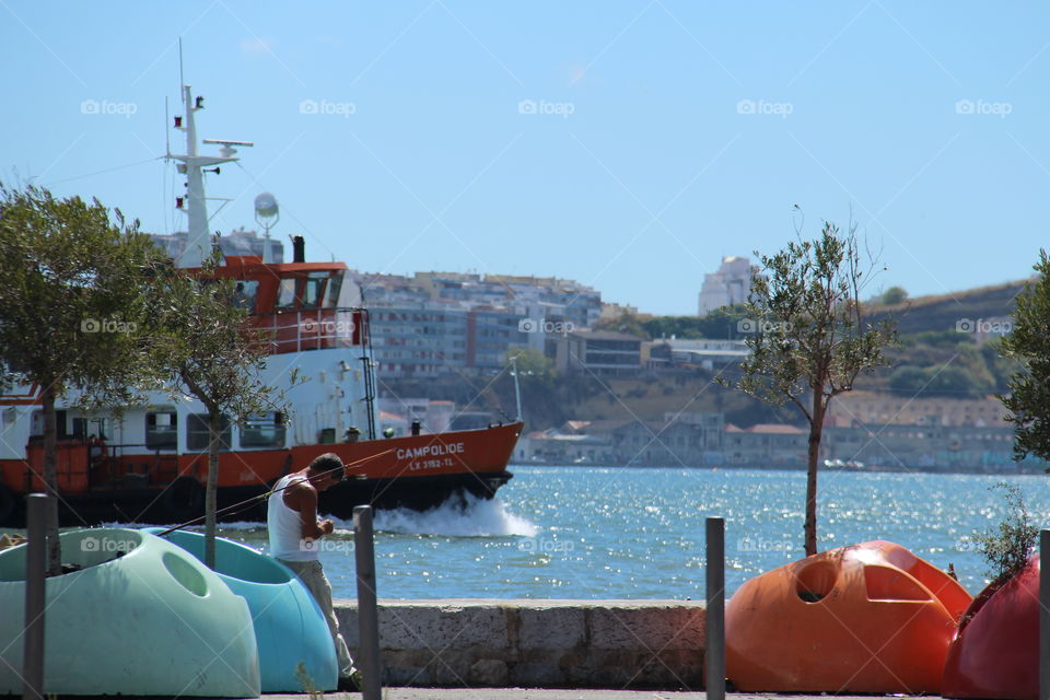 Cais do Sodré. man fishing on Lisbon tagus riverside