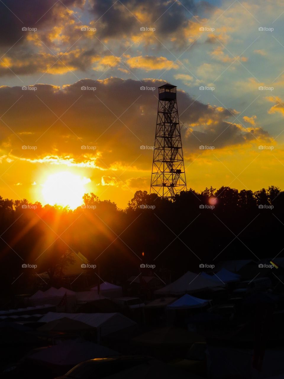 Fire Tower. An old fire tower in the countryside, against an illuminated golden sky at sunset