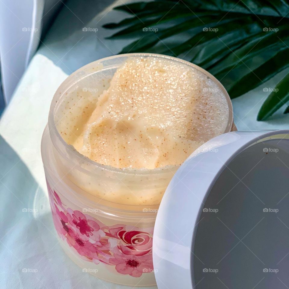 Body scrub in rose flavour set against a natural backdrop 