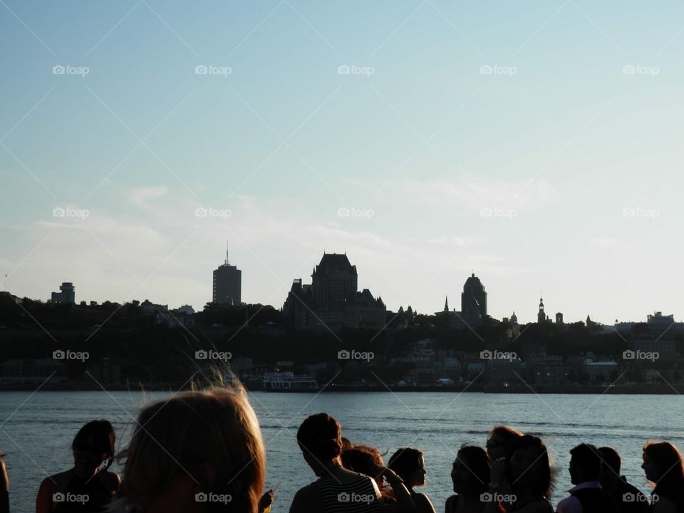 Young people watch the Quebec City skyline on a warm summer night 