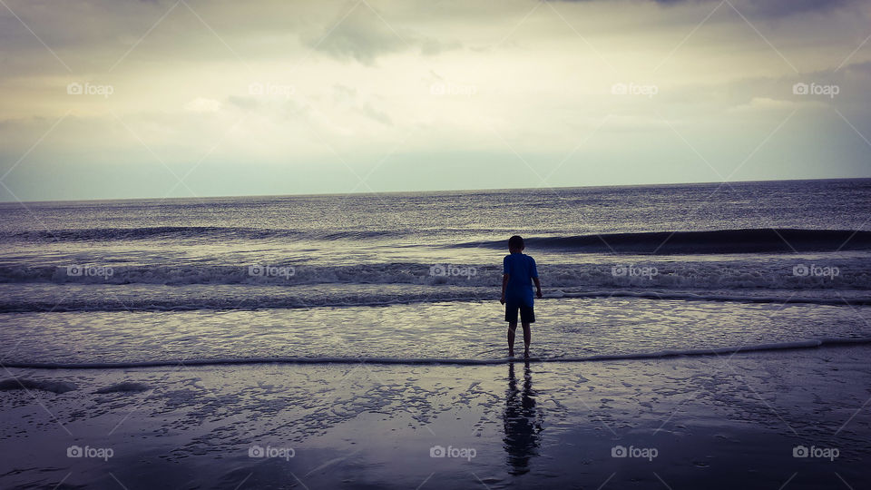 Edisto Beach. A young man playing in the wake on Edisto Beach in South Carolina. 