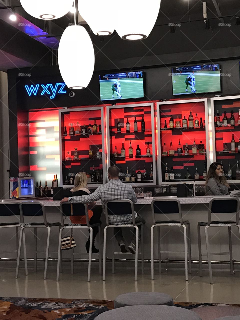 A couple sitting at a bar with a backdrop of bright colors!