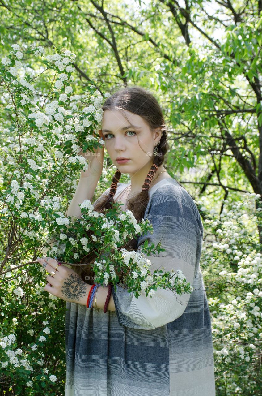 Portrait of Young Girl on Background of Flowers