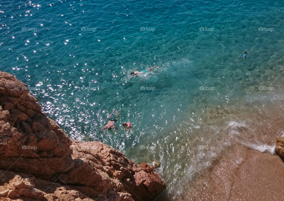 people swimming in turquoise sea