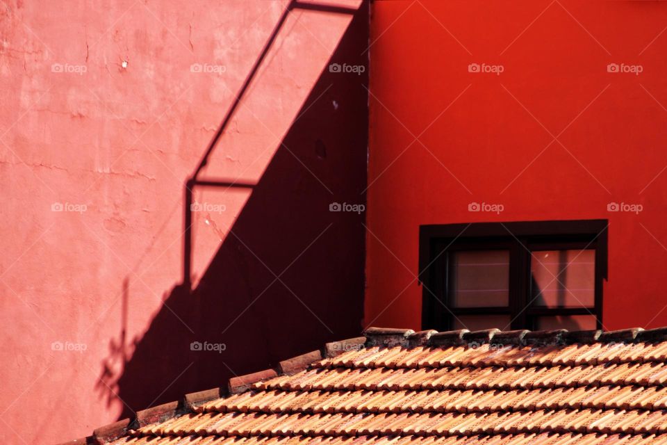 Light and shadow on a red building with tiled roof 