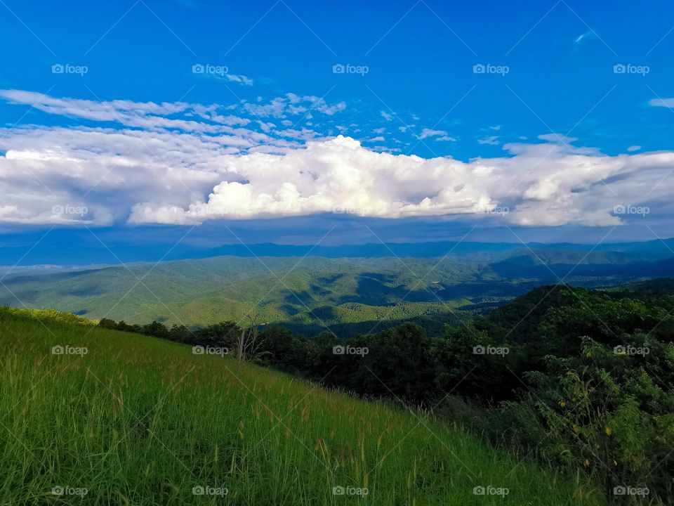 The greenery of the hillsides stretch as far as the eye can see at the top of Doi Samer Dao in Nan, Thailand.