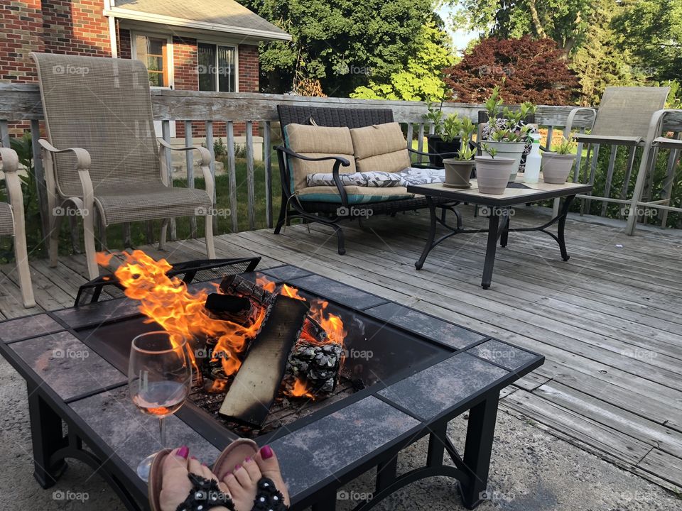 Sitting on the deck in front of a fire pit drinking wine