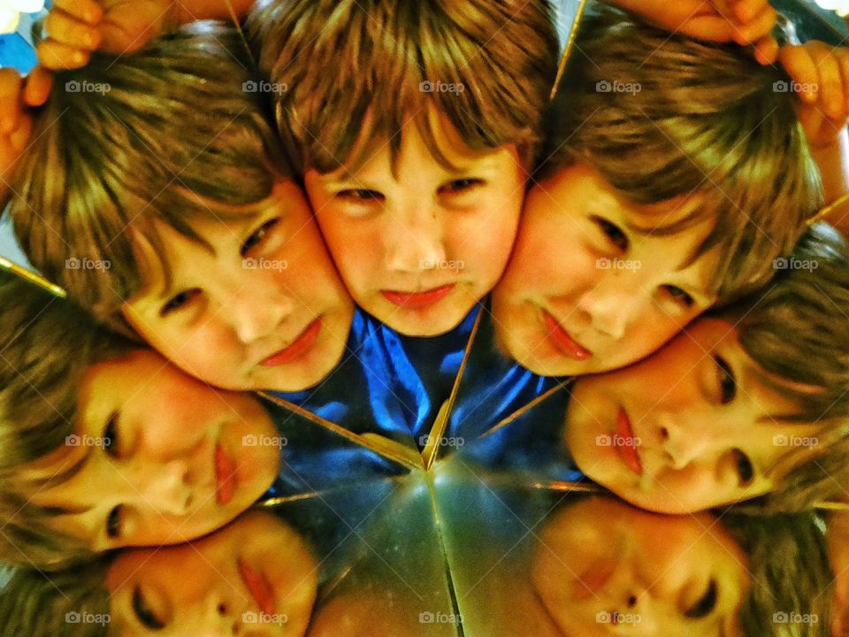 Fun With Mirrors. Boy's Face Reflected Many Times In A Trick Mirror