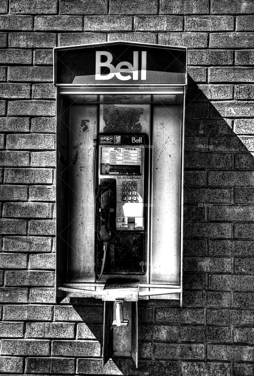 A pay phone sits forgotten on a wall, practically forgotten Ina generation of cellular devices. Taken in Peterborough, Ontario 