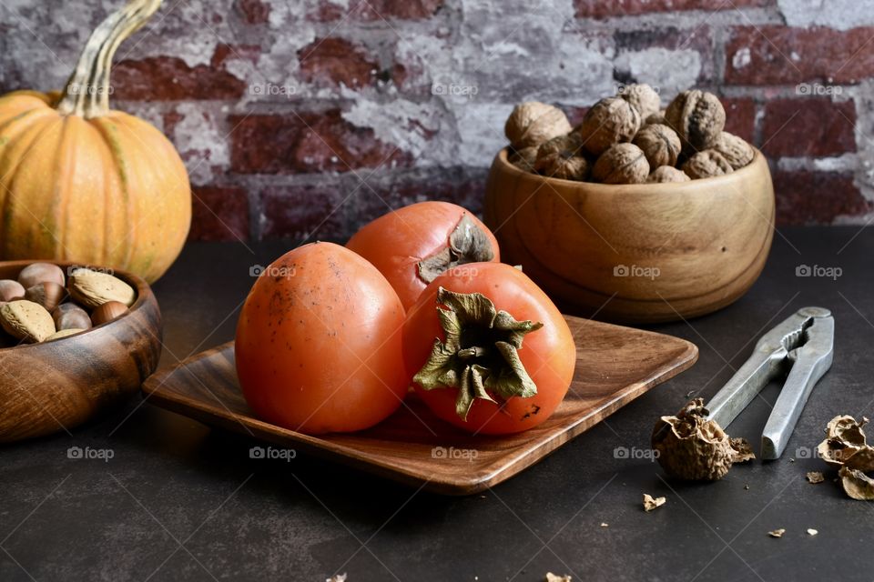 Persimmon and nuts on a table 