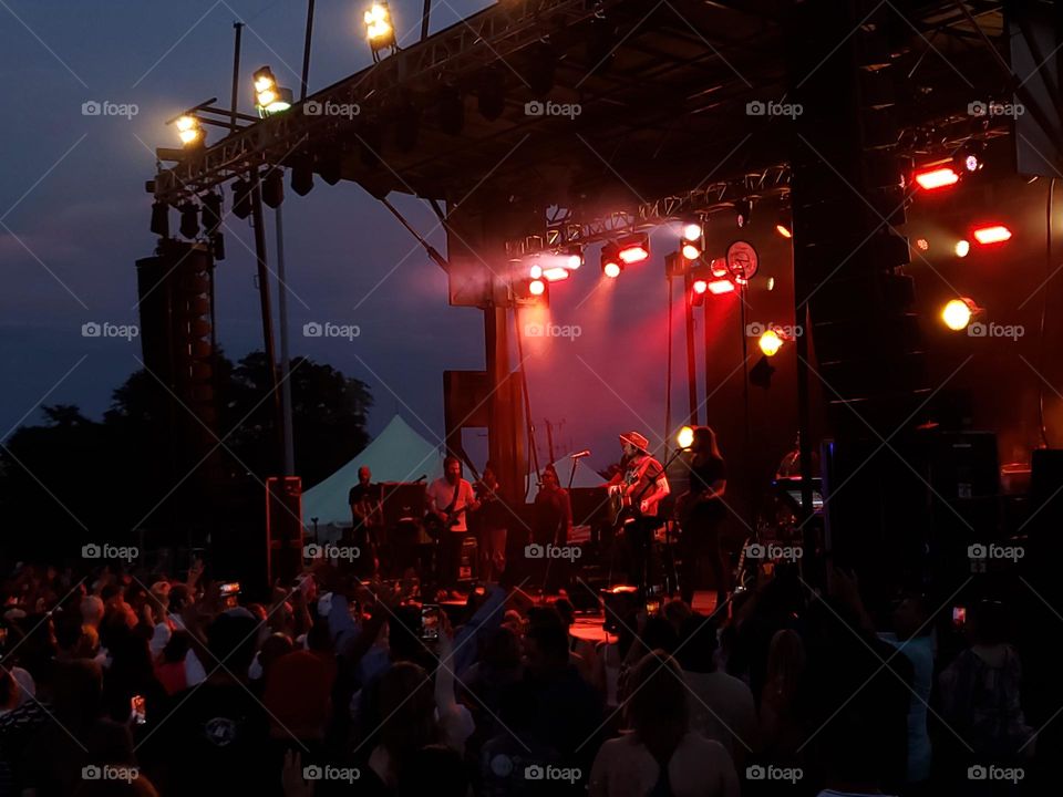 A crowd at an evening outdoor concert.