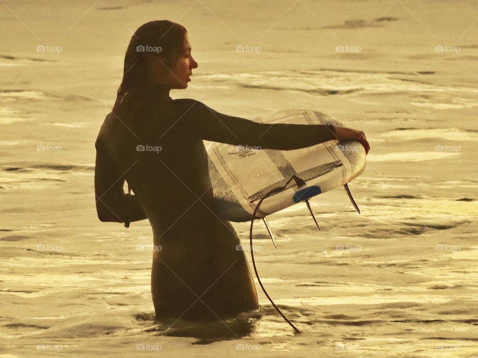 Woman With Surfboard In The Ocean