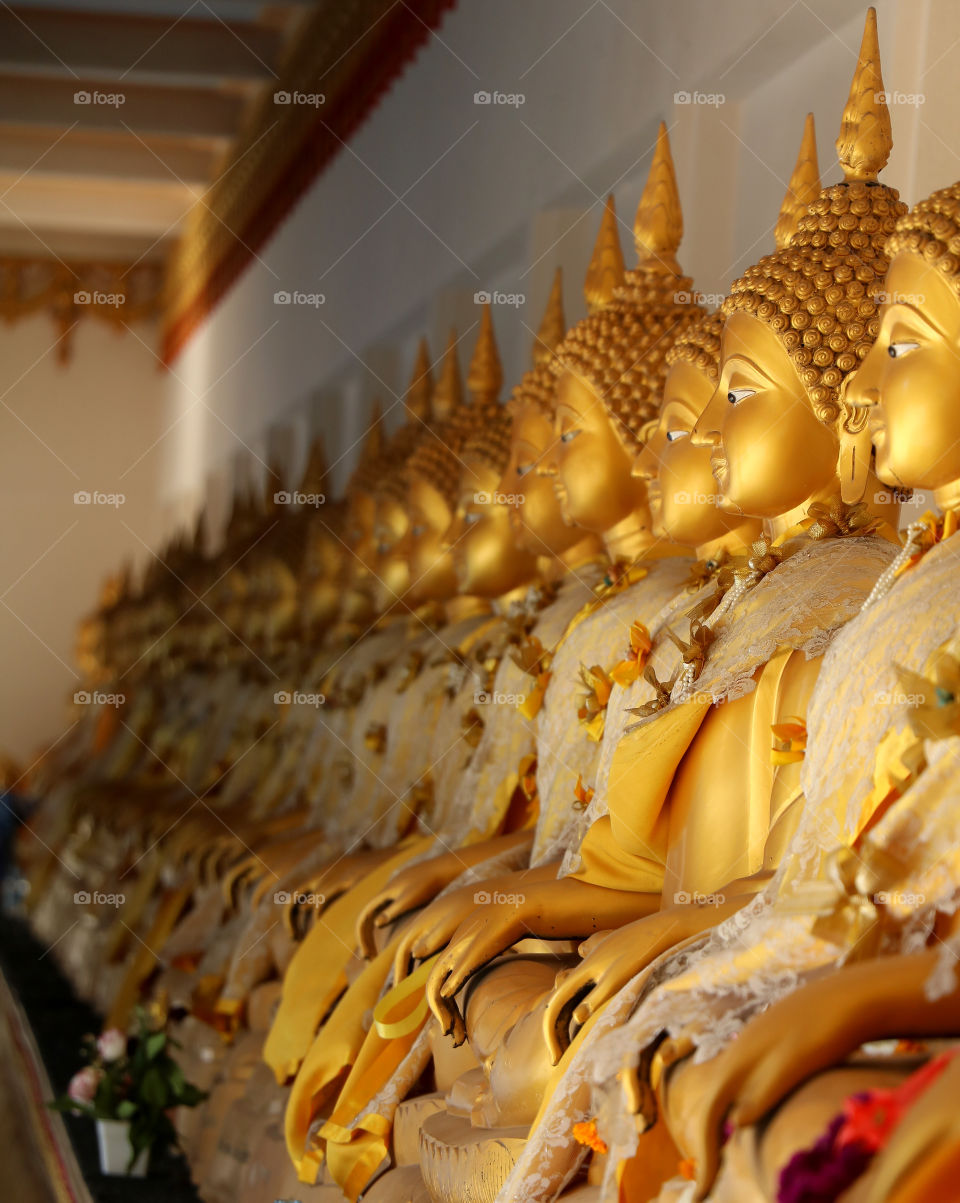 Row of​ golden​ buddha​ statues.