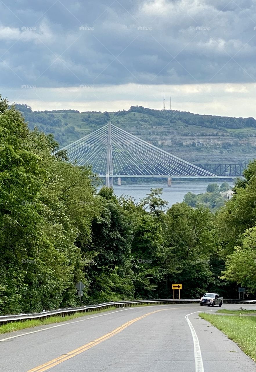 Rural country road with the river and bridge in the background 