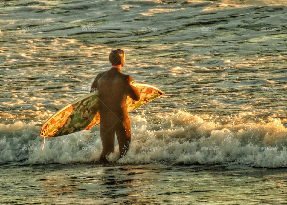 Surfer entering the ocean at Año Nuevo Beach in Northern California
