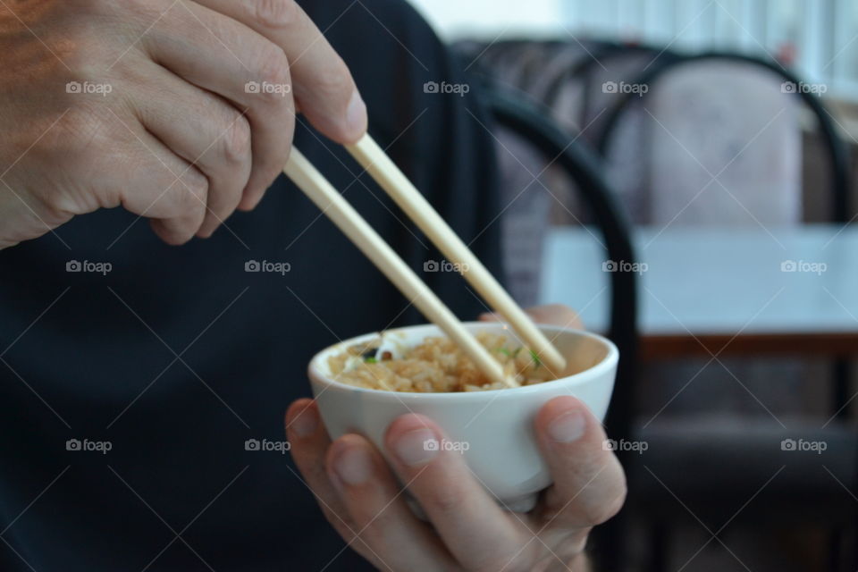 A bowlof Chinese rice eaten the traditional way with chopsticks from a small bowl