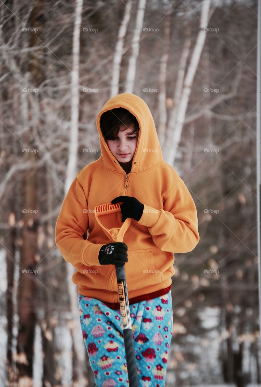 Teenage boy holding shovel in hand