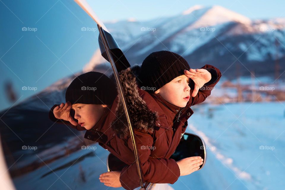 Boy looking out the car window in winter