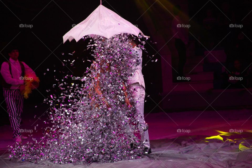 New Year's magic in a performance on stage. girl in the rain of glitter.