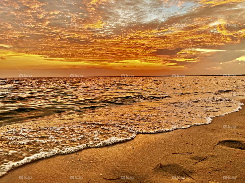 Magic of Sunrise and Sunset - The glowing, descending setting sun gave a warm orange tinge to the sky and cast an iridescent shadow on the Gulf of Mexico below