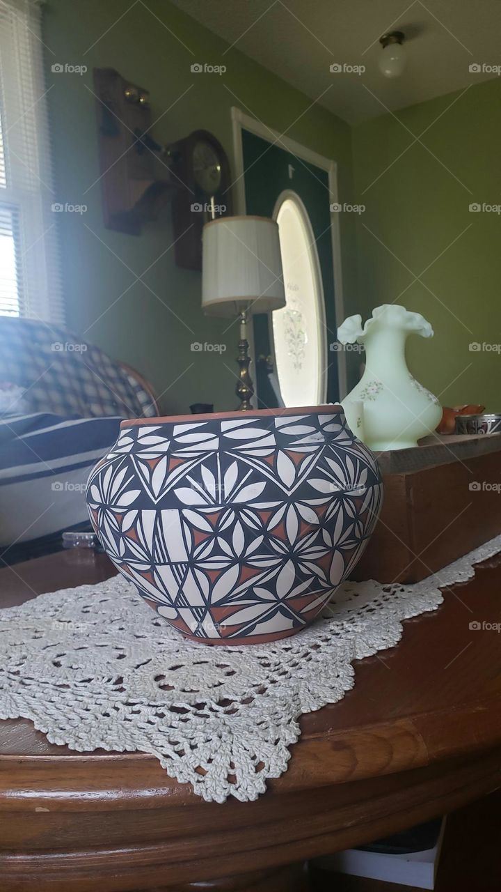 Pottery vase native American style. Distinctive placement of white leaf decoration on blue background.