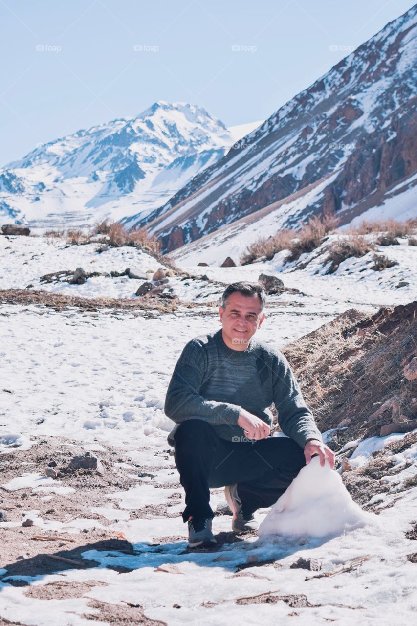 adult man having fun in front of a snow mountain