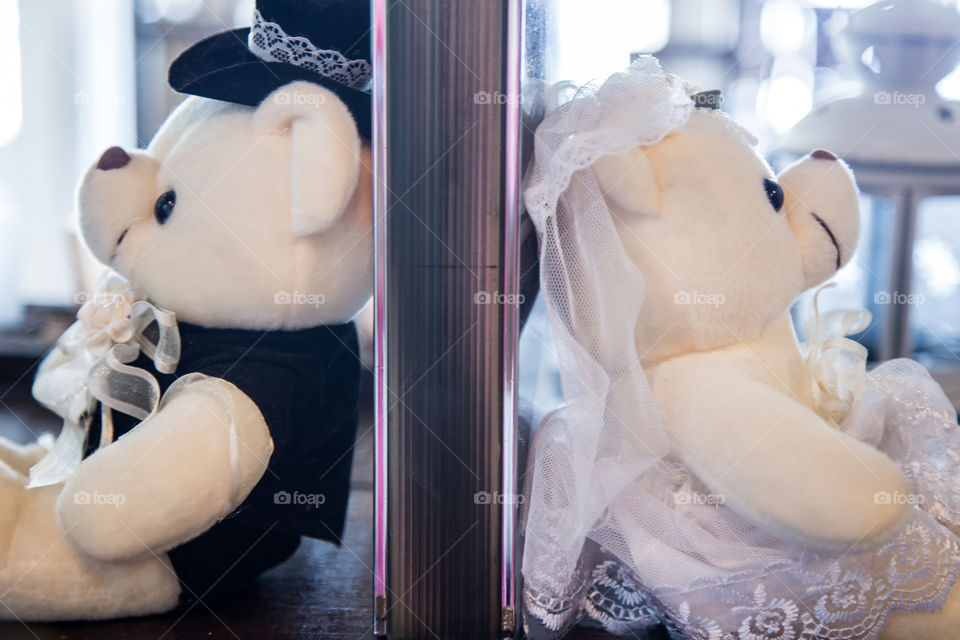 Teddy bears in wedding costume sitting back to back